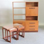 A 1970's teak bookcase, together with a nest of three teak and glass top occasional tables,