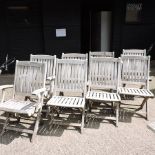 A set of eight teak folding slatted garden chairs