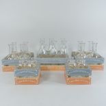 A collection of decorative miniature glass bottles, in painted wooden crates,