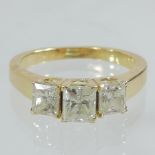 An 18 carat gold princess cut three stone diamond ring, 1.