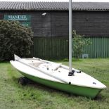 A Laser dinghy, with an aluminium mast, centreboard and rudder, on a trailer,