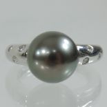 An 18 carat white gold black pearl and diamond ring