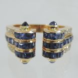 A yellow metal three band sapphire and diamond torque shaped ring