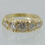 An 18 carat gold diamond boat shaped ring, set with a row of five graduated stones,