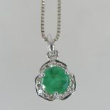 An 18 carat white gold, emerald and diamond pendant, on a fine chain,