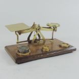 A set of brass postal scales, on a wooden base,
