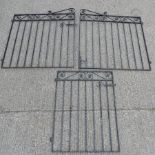 A pair of black painted wrought iron gates, 250 x 131cm overall, together with another smaller gate,