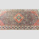 A Persian woollen carpet, with a large central medallion, on a red ground,