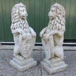 A pair of reconstituted stone seated lions,