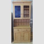 An antique pine dresser, with drawers and cupboards below,