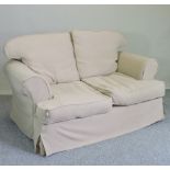 A tan upholstered two seater sofa, with loose covers,