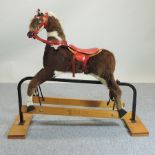 A stuffed rocking horse, on a wooden base,
