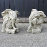 A pair of reconstituted stone models of elephants,