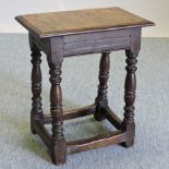 An 18th century oak joint stool, on a splayed base,