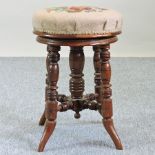 A Victorian walnut and tapestry upholstered revolving piano stool