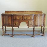 An early 20th century walnut bow front sideboard, of Queen Anne style, on turned legs,