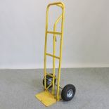 A yellow painted metal sack barrow