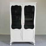 A cream painted glazed bookcase, on cabriole legs,