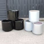 A set of three black garden pots, 45cm diameter, together with a set of three silver garden pots,