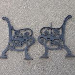 A pair of black painted iron bench ends,