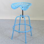 A blue painted metal tractor seat bar stool