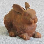 A rusted metal model of a seated rabbit,