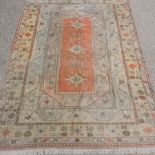 A large Turkish Melas carpet, with three central lozenges and geometric designs, on a beige ground,