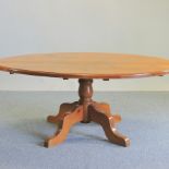 A modern oval pine pedestal dining table,