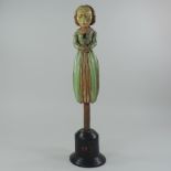 A painted wooden figural carving, on a wooden base, signed 88 YB,