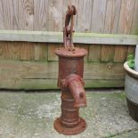 A rusted metal garden pump,