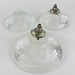 A set of three circular glass light shades,