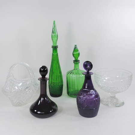A collection of coloured glass decanters,