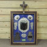 A collection of funereal plaques, mounted in a display frame,