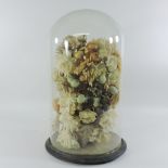 A Victorian glass dome, on stand, containing silk flowers,