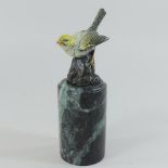 A cold painted bronze model of a bird, on an onyx base,