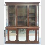 A large early 20th century mahogany triple bookcase, with mirrored doors below,
