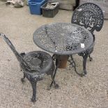 A black painted metal circular garden table, 66cm diameter, with a pair of matching chairs,
