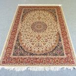A Keshan rug, with a central medallion and floral designs, on a cream ground,