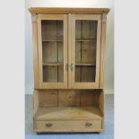 An antique style pine glazed bookcase,