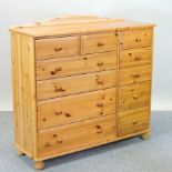 A modern pine chest, containing an arrangement of drawers,