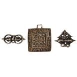 THREE AMULETIC PENDANTS (TOKCHA), TIBET, 15TH CENTURY OR LATER cast brass, two in the form of closed