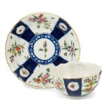 A WORCESTER POLYCHROME TEABOWL AND SAUCER, CIRCA 1770 fluted, painted with panels of flowers
