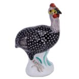 A MEISSEN MINIATURE FIGURE OF A GUINEA FOWL, CIRCA 1745 with dotted black plumage, on a tree stump