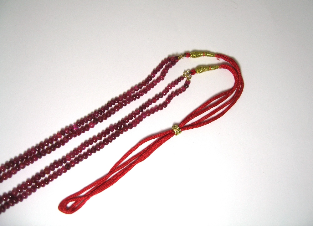 RUBY NECKLACE designed as two graduated rows of polished ruby beads on an adjustable cord - Image 3 of 3