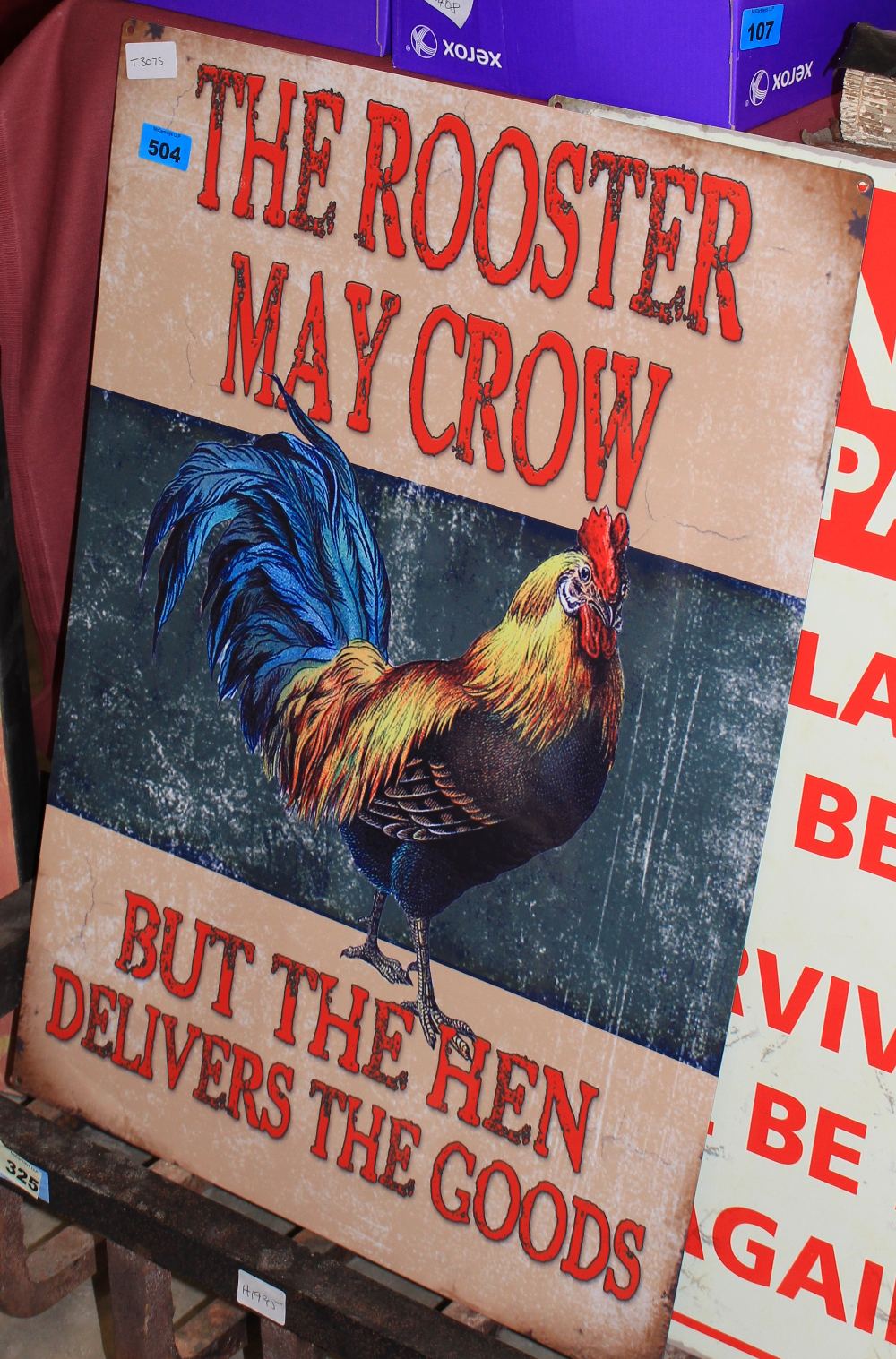 A tin sign decorated with a rooster