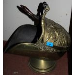 A brass embossed helmet coal scuttle with irons