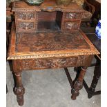 An oak carved bonheur du jour with frieze drawer on knopped turned legs. 30" wide