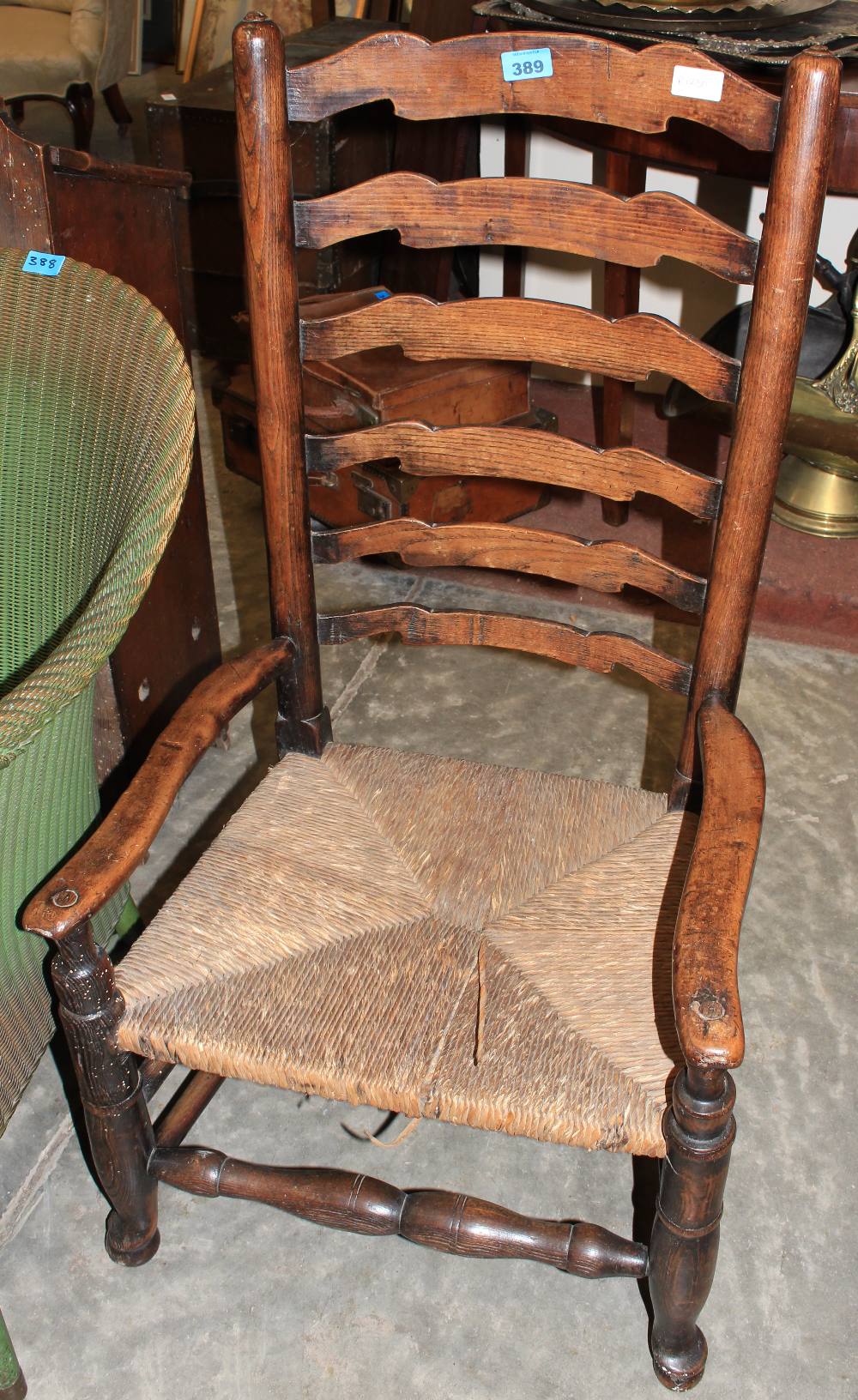 A 19th Century country ladderback chair with rush seat on pad feet