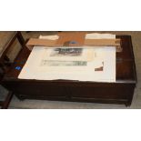 An oak underbed storage box with various unframed prints