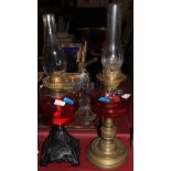 Two Victorian oil lamps, brass or iron based, each with cranberry glass reservoir